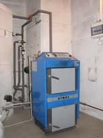 ATMOS kotel na dřevo s distribučním potrubím v kotelně